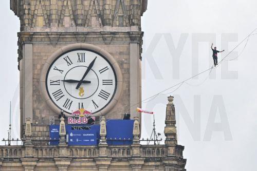 epa13006240 Estonian slackliner Jaan Roose walks on a 2 cm-wide line 180 meters above the ground between the Palace of Culture and Science and Varso Tower, the two tallest buildings in Warsaw, Poland, 31 May 2026. The event is sponsored by an energy drink producer.  EPA/PIOTR NOWAK POLAND OUT