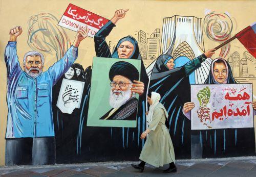 epa13012532 An Iranian woman walks next to an anti-US and Israeli mural in Tehran, Iran, 03 June 2026. Iran and the US traded strikes despite a ceasefire as the conflict involving Iran, the US, and Israel continues. According to US Central Command (CENTCOM), US forces intercepted multiple Iranian ballistic missiles and drones and conducted self-defense...