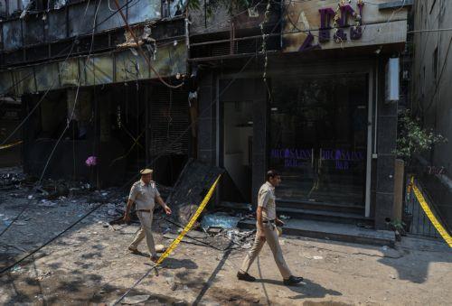 epa13012769 Police personnel are seen at the site of fire in a hotel in New Delhi, India, 03 June 2026. According to authorities, at least 21 people have died and several others have been seriously injured following a fire in a hotel in the Malviya Nagar area of New Delhi.  EPA/RAJAT GUPTA