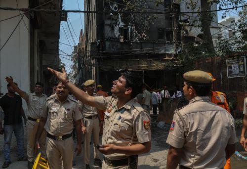epa13012813 Police officers are seen at the site of fire in a hotel in New Delhi, India, 03 June 2026. According to authorities, at least 21 people have died and several others have been seriously injured following a fire in a hotel in the Malviya Nagar area of New Delhi.  EPA/RAJAT GUPTA
