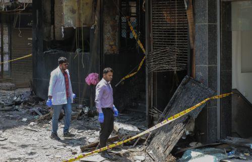 epa13012898 Forensic team members inspect the site of fire in a hotel in New Delhi, India, 03 June 2026. According to authorities, at least 21 people have died and several others have been seriously injured following a fire in a hotel in the Malviya Nagar area of New Delhi.  EPA/RAJAT GUPTA