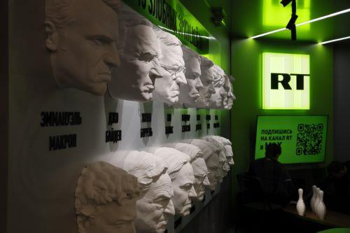 epa13017480 A participant sits near masks of European and US leaders on the 'Russia Today' (RT) TV company's corner during the St. Petersburg International Economic Forum (SPIEF) in St. Petersburg, Russia, 05 June 2026. The 29th St. Petersburg International Economic Forum runs from 03 to 06 June 2026.  EPA/ANATOLY MALTSEV