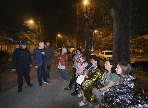 epa13025588 Local people stand at the site of a Russian strike on a residential area in Kharkiv, Ukraine, 09 June 2026, amid the ongoing Russian invasion. At least three people were killed and 18 injured, including two children, as Russia attacked Kharkiv and the region, according to the State Emergency Service.  EPA/SERGEY KOZLOV