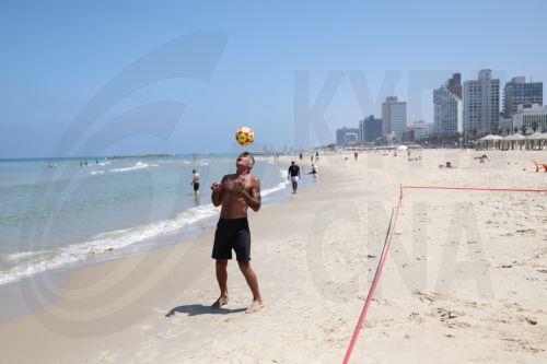 epa13025720 A man plays soccer on the beach in Tel Aviv, Israel, 09 June 2026. The Israeli Home Front Command has lifted restrictions and most of Israel is returning to normal activity, while several northern communities remain under partial restrictions.  EPA/ABIR SULTAN