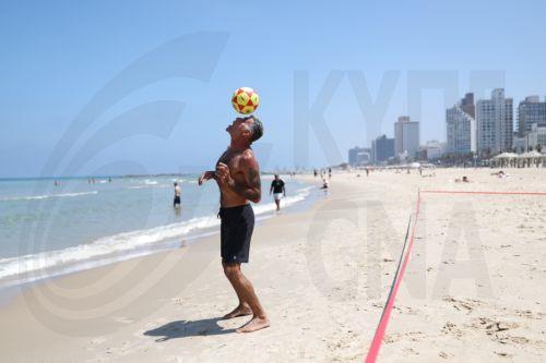 epa13025722 A man plays soccer on the beach in Tel Aviv, Israel, 09 June 2026. The Israeli Home Front Command has lifted restrictions and most of Israel is returning to normal activity, while several northern communities remain under partial restrictions.  EPA/ABIR SULTAN