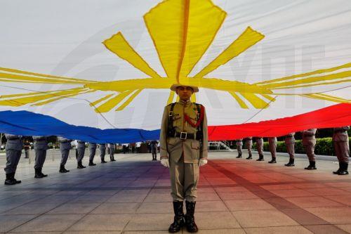 epa13031706 A member of the Philippine Army Security and Escort Battalion stands under a giant Philippine flag during ceremonies marking the 128th Philippine Independence Day anniversary at the Jose Rizal Monument of Luneta Park in Manila, Philippines, 12 June 2026. The Philippines declared independence on 12 June 1898 after more than 300 years of Spanish...