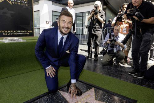 epa13033487 British former soccer player David Beckham (C) poses next to his star during a ceremony honoring him on the Hollywood Walk of Fame in Los Angeles, California, USA, 12 June 2026. Beckham was recognized in the Sports Entertainment category.  EPA/TED SOQUI