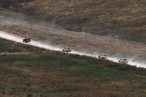 epa13044299 Military vehicles move within southern Lebanon, as seen from the Israeli side of the border in the Upper Galilee, northern Israel, 17 June 2026. An Israeli army spokesperson reported that a soldier was severely injured, two soldiers were moderately injured, and two additional soldiers were lightly injured as a result of an explosive drone impact...