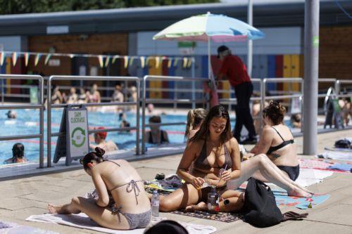epa13058190 People sunbathe and swim at London Fields Lido outdoor swimming pool as the UK is set to experience its hottest June day on record during a heatwave in London, Britain, 23 June 2026. The Met Office has issued an amber warning for 23 June and its second-ever red warning for extreme heat for 24 June, with temperatures expected to reach at least 39...