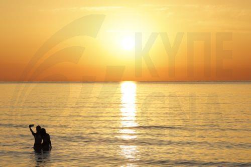 epa13060122 Revelers take a selfie at sunrise while bathing in the sea at Malvarrosa Beach after the Night of San Juan celebrations in Valencia, Spain, 24 June 2026. To welcome the summer solstice, Spain comes alive during the Night of San Juan from 23 to 24 June. The celebration features bonfires on beaches and town squares, culminating at midnight when...