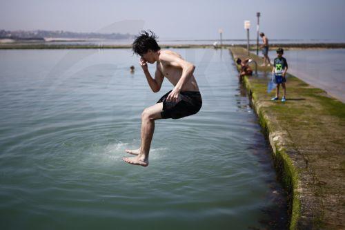 epa13060760 A young person plunges into the water on Margate Main Sands Beach as the UK is set to experience its hottest June day on record during a heatwave in Margate, Kent, Britain, 24 June 2026. The Met Office has issued its second ever red warning for extreme heat, as temperatures are expected to reach at least 39 Celsius, with some areas potentially...