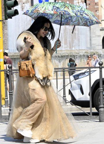 epaselect epa13060711 A woman wearing a fur scarf walks under an umbrella during a heatwave in Milan, Italy, 24 June 2026. An intense heatwave continues in Western and Central Europe, pushing temperatures far above seasonal norms for mid-June.  EPA/DANIEL DAL ZENNARO