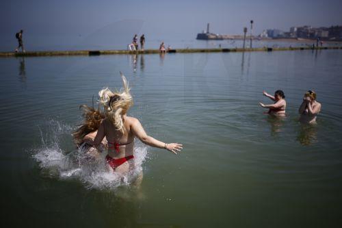 epaselect epa13060761 Young people plunge into the water on Margate Main Sands Beach as the UK is set to experience its hottest June day on record during a heatwave in Margate, Kent, Britain, 24 June 2026. The Met Office has issued its second ever red warning for extreme heat, as temperatures are expected to reach at least 39 Celsius, with some areas...
