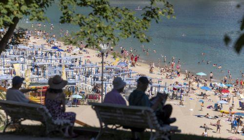 epa13060784 People rest in the shade in front of La Concha beach in San Sebastian, Basque Country, northern Spain, 24 June 2026. The temperature is forecast to reach up to 37 degrees Celsius in the city during the day.  EPA/Javier Etxezarreta