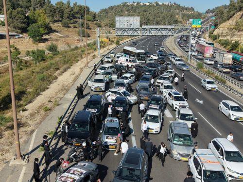 epa13061130 Ultra-Orthodox Jews driving in a convoy of cars to disrupt traffic as part of a national protest against the army recruitment in Jerusalem, 24 June 2026. Ultra-Orthodox protesters in various locations of the country disrupted traffic, calling for a protest against the conscription of ultra-Orthodox Jews into the IDF.  EPA/ABIR SULTAN EPA