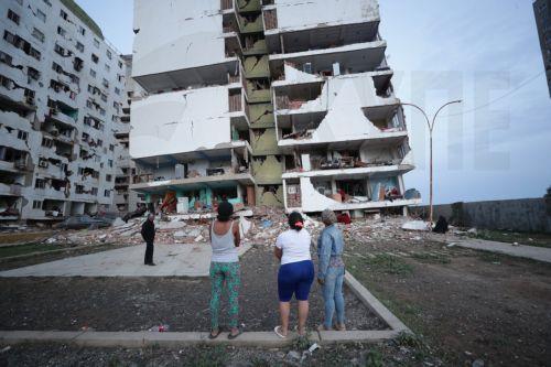 epa13063441 Residents look at a building damaged during the twin 7.2 and 7.5-magnitude earthquakes that struck the country, in Catia la Mar, Venezuela, 25 June 2026. At least 32 people were killed and 700 were injured after two back-to-back earthquakes hit north-central Venezuela in rapid succession, triggering the collapse of buildings, cracking facades,...