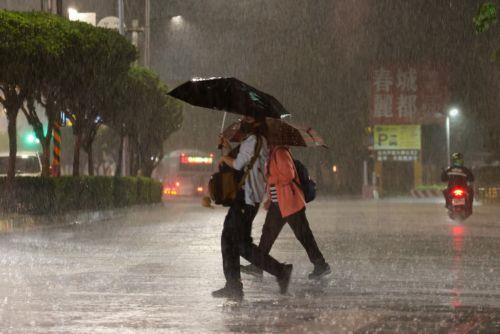 epa13063452 People walk across the street during a downpour of rain in Taipei, Taiwan, 25 June 2026. The local authorities in Hualien County ordered evacuations in parts of Wanrong and Fenglin following a yellow alert that a nearly full upstream barrier lake might overflow within 48 hours. Rainfall tied to Severe Tropical Storm Mekkhala was expected,...
