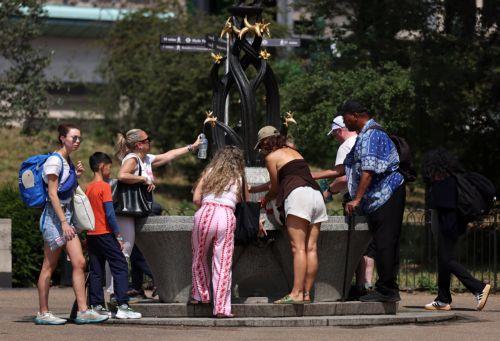 epa13066331 Park goers drink and fill water bottles at a fountain during hot weather in London, Britain, 26 June 2026. The Met Office's red warning of extreme heat is still in place for the East and South East of England, as a heatwave continues to grip much of the UK.  EPA/ANDY RAIN