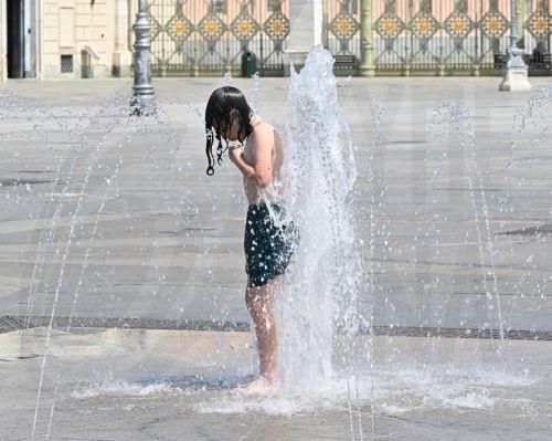 epa13066348 A child tries to stay cool during a heatwave in Turin, Italy, 26 June 2026. In Italy, 18 cities are under a "red alert" for the next 48 hours due to heat-related risks. Temperatures are expected to exceed 40 degrees celsius.  EPA/Alessandro Di Marco