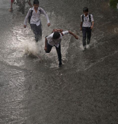 epa13072416 Students run through a water logged street during heavy rain in Kolkata, India, 29 June 2026. The India Meteorological Department (IMD) issued a red alert for thunderstorms with lightning and heavy rainfall, disrupting daily life across parts of West Bengal for the past several days.  EPA/PIYAL ADHIKARY