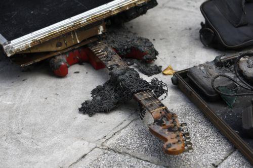 epa13107983 A charred guitar lies outside a pub that was the scene of a fatal fire in Bangkok, Thailand, 13 July 2026. At least 27 people were killed and 63 others were injured after a fire engulfed the pub, according to the Royal Thai Police.  EPA/RUNGROJ YONGRIT