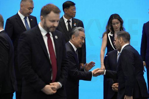 epa13115198 Chinese Foreign Minster Wang Yi (C) chats with other signatories after a group photo for the Agreement on the Establishment of The World Artificial Intelligence Cooperation Organization ahead of the World AI Conference in Shanghai, China, 16 July 2026.  EPA/NG HAN GUAN / POOL
