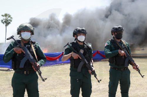 epa13124122 Cambodian police officers stand guard during a drug destruction event in Kandal province, Cambodia, 21 July 2026. The Cambodian National Authority for Combating Drugs destroyed nearly five tons of illegal drug substance ingredients in an effort to fight against drug production, distribution and drug trafficking.  EPA/KITH SEREY
