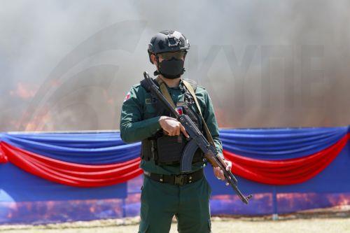 epa13124124 A Cambodian police officer stands guard during a drug destruction event in Kandal province, Cambodia, 21 July 2026. The Cambodian National Authority for Combating Drugs destroyed nearly five tons of illegal drug substance ingredients in an effort to fight against drug production, distribution and drug trafficking.  EPA/KITH SEREY