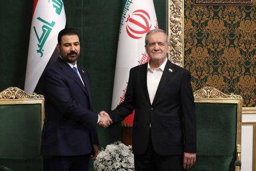 epa13127829 A handout picture made available by the Iranian presidential office shows Iranian President Masoud Pezeshkian (R) shaking hands with Iraqi Prime Minister Ali al-Zaidi (L) during their meeting in Tehran, Iran, 23 July 2026. The Iraqi prime minister is on an official diplomatic trip to Tehran to hold talks with senior Iranian officials. ...