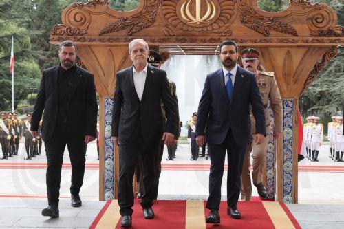 epa13127860 A handout picture made available by the Iranian presidential office shows Iranian President Masoud Pezeshkian (C) welcoming Iraqi Prime Minister Ali al-Zaidi (R) during a ceremony in Tehran, Iran, 23 July 2026. The Iraqi prime minister is on an official diplomatic trip to Tehran to hold talks with senior Iranian officials.  EPA/IRANIAN...