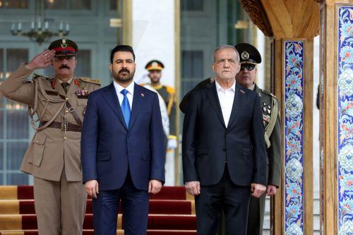 epa13127861 A handout picture made available by the Iranian presidential office shows Iranian President Masoud Pezeshkian (R) welcoming Iraqi Prime Minister Ali al-Zaidi (C) during a ceremony in Tehran, Iran, 23 July 2026. The Iraqi prime minister is on an official diplomatic trip to Tehran to hold talks with senior Iranian officials.  EPA/IRANIAN...