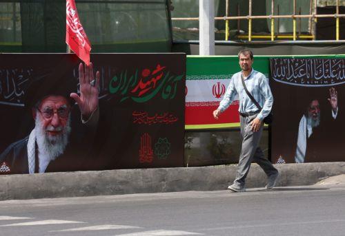 epa13129789 An Iranian man walks next to the pictures of late Iranian supreme leader Ayatollah Ali Khamenei on a street in Tehran, Iran, 24 July 2026.  Conflict between Iran and the US over the Strait of Hormuz continues, as US strikes have targeted several locations across Iran.  EPA/ABEDIN TAHERKENAREH RESTRICTIONS: NO Access Israel Media/Persian Language...