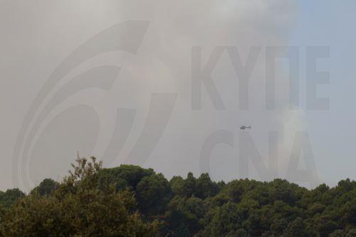 epa13129858 A firefighting helicopter flies as the smoke from a wildfire rises in Pelayos de la Presa municipality, Community of Madrid, Spain, 24 July 2026. Commanders of the operation against the forest fire affecting the southwest of the Autonomous Community of Madrid ordered the evacuation of the municipalities of Chapineria, Navas del Rey, and Colmenar...
