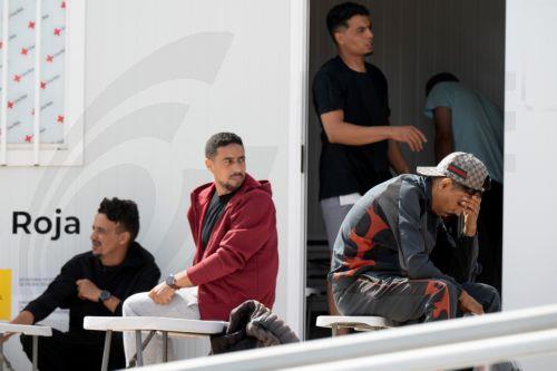 epa13130177 Newly arrived migrants wait at a Red Cross point in the port of Gran Tarajal, Fuerteventura, Spain's Canary Islands, 24 July 2026. About 20 migrants arrived on Fuerteventura island aboard a possibly stolen fishing vessel from El Aaiun, Western Sahara, according to the Civil Guard and emergency services.  EPA/CARLOS DE SAA