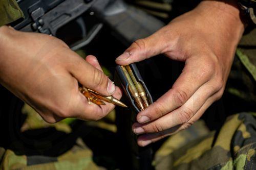 epa13130749 A high school student loads a magazine for a CZ BREN 2 assault rifle as he trains in basic military skills under the guidance of instructors during the final field exercise of a month-long voluntary military training course organized by the Czech Army at the Hradiste Military Area, near Bochov, Czech Republic, 24 July 2026. The Hradiste Military...