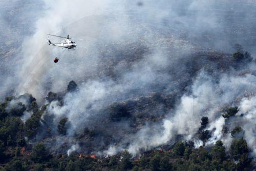 epaselect epa13132526 Helicopters deployed to extinguish wildfires fly over the fire in La Vall d'Uixo, Spain, 25 July 2026. Tens of thousands of people were evacuated due to the fires across Spain, according to the interior ministry.  EPA/Manuel Bruque