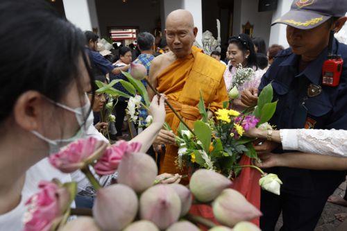 epa13141335 A Thai Buddhist monk collects flowers from devotees during the floral alms offering ceremony marking the start of Buddhist Lent or 'Khao Phansa' at Wat Phra Chetuphon Wimonmangkalaram Ratchaworamahawihan or Wat Pho in Bangkok, Thailand, 30 July 2026. The traditional floral alms offering is held to mark the start of Buddhist Lent, which begins...