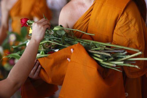 epa13141336 Thai devotees offer flowers to Buddhist monks during the floral alms offering ceremony marking the start of Buddhist Lent or 'Khao Phansa' at Wat Phra Chetuphon Wimonmangkalaram Ratchaworamahawihan or Wat Pho in Bangkok, Thailand, 30 July 2026. The traditional floral alms offering is held to mark the start of Buddhist Lent, which begins this...