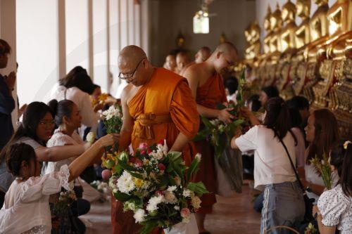 epa13141337 Thai devotees offer flowers to Buddhist monks during the floral alms offering ceremony marking the start of Buddhist Lent or 'Khao Phansa' at Wat Phra Chetuphon Wimonmangkalaram Ratchaworamahawihan or Wat Pho in Bangkok, Thailand, 30 July 2026. The traditional floral alms offering is held to mark the start of Buddhist Lent, which begins this...