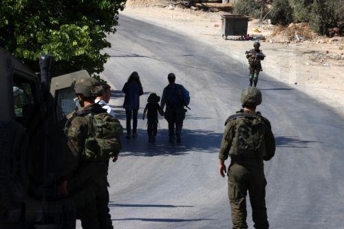 epa13143505 Israeli soldiers guard Israeli settlers entering the village of Sara, near the West Bank city of Nablus, 31 July 2026. According to the Palestinian news agency WAFA, a Palestinian man was injured when Israeli soldiers fired live bullets at a group of Palestinians in the Al Jouned area, as dozens of Israeli settlers marched through the...
