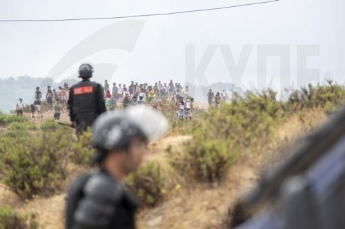 epa13143773 Members of the Moroccan security forces and civilians who returned from Spain gather at the site of clashes at the Bab Sebta border crossing near Fnideq, Morocco, 31 July 2026. The unrest erupted as thousands of migrants attempted to cross into Ceuta and clashed with Moroccan security forces.  EPA/JALAL MORCHIDI