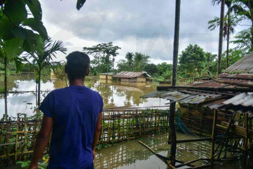 epa13151284 A man stands near his partially submerged house following heavy monsoon rains in Kalapani village, Nagaon district, Assam, India, 05 August 2026. According to the Assam State Disaster Management Authority (ASDMA), the death toll from severe flooding in the north-eastern state of Assam has risen to 89, with over 200,000 residents across the state...