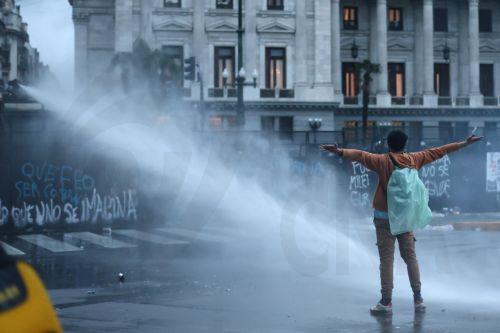 epa13154755 A protester receives water from a member of the Argentine Federal Police during a demonstration against a bill promoted by the government of President Javier Milei introducing changes to eviction procedures, expropriations, and the use of burned land, in Buenos Aires, Argentina, 06 August 2026.  EPA/Juan Ignacio Roncoroni