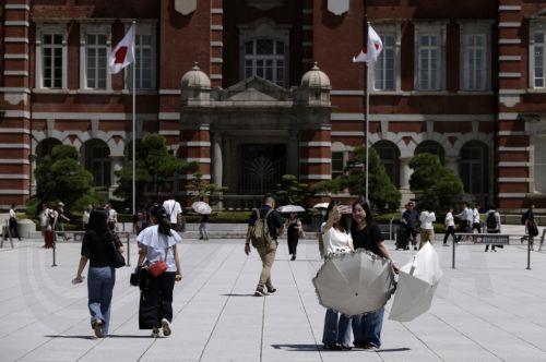 epa13155053 Passersby holding umbrellas to shelter from the sun walk in front of Tokyo Station, in Tokyo, Japan, 07 August 2026. Tokyo has endured a summer of persistent heat, with temperatures frequently exceeding 35 degrees Celsius, prompting authorities to issue heatstroke warnings.  EPA/FRANCK ROBICHON