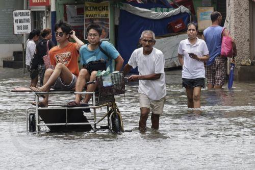 epa13158724 People ride a tricycle along a flooded road in Rizal province, northeast of Metro Manila, Philippines 10 August 2026. Persistent monsoon rains in Metro Manila and several provinces in the Luzon region caused flooding and triggered evacuations by emergency response units to ensure the safety of residents.  EPA/ROLEX DELA PENA