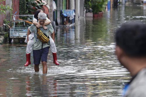 epa13158731 A man carries his wife while walking through floodwater in Pasig City, Metro Manila, Philippines, 10 August 2026. Persistent monsoon rains in Metro Manila and several provinces in the Luzon region caused flooding and triggered evacuations by emergency response units to ensure the safety of residents.  EPA/ROLEX DELA PENA