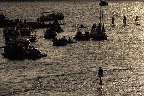 epa13181904 People gather on the Main River during the European Open Air concert in Frankfurt am Main, Germany, 20 August 2026. The annual event brings spectators to the riverbanks and onto the water for open-air orchestral music performances.  EPA/MATIAS BASUALDO