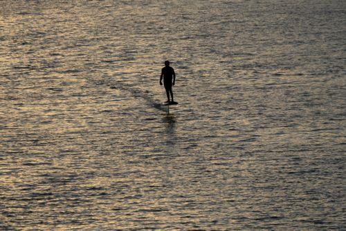 epa13181905 A person rides a hydrofoil surfboard on the Main River at sunset in Frankfurt am Main, Germany, 20 August 2026.  EPA/MATIAS BASUALDO