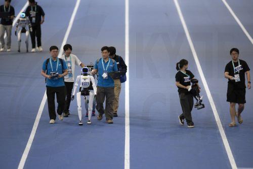 epa13186086 Team members set a humanoid robots for the small robots 400m event during the 2026 World Humanoid Robot Games at the National Speed Skating Oval in Beijing, China, 23 August, 2026. The 2026 World Humanoid Robot Games are being held in Beijing until 26 August.  EPA/ANDRES MARTINEZ CASARES