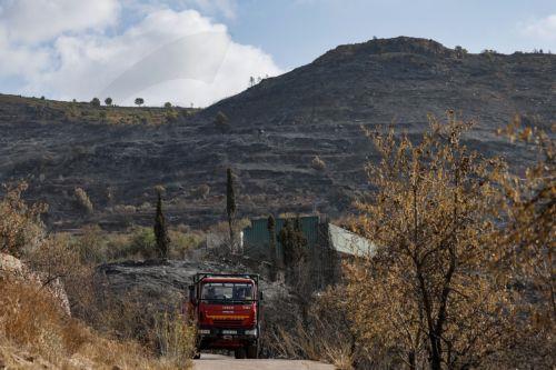 epa13186132 Burnt land is seen in the background in Gatova, Valencia, Spain, 23 August 2026. The fire, caused by lightning on 20 August in Segorbe, Castellon, has been stabilized, according to the Emergency Services.  EPA/MANUEL BRUQUE